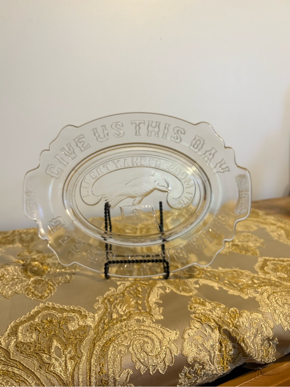 Clear glass commemorative plate with patriotic and religious embossed designs.